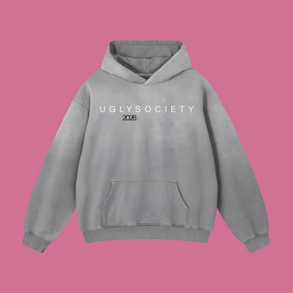 A light gray hooded sweatshirt with 'UGLYSOCIETY 2026' printed in white across the chest, displayed on a clean white background.