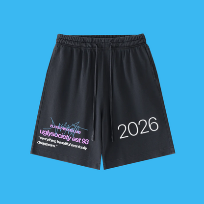 Black athletic shorts with an elastic waistband and drawstring, featuring white '2026' text on the right leg and a purple graphic print with white text on the left leg, shown against a plain white background.
